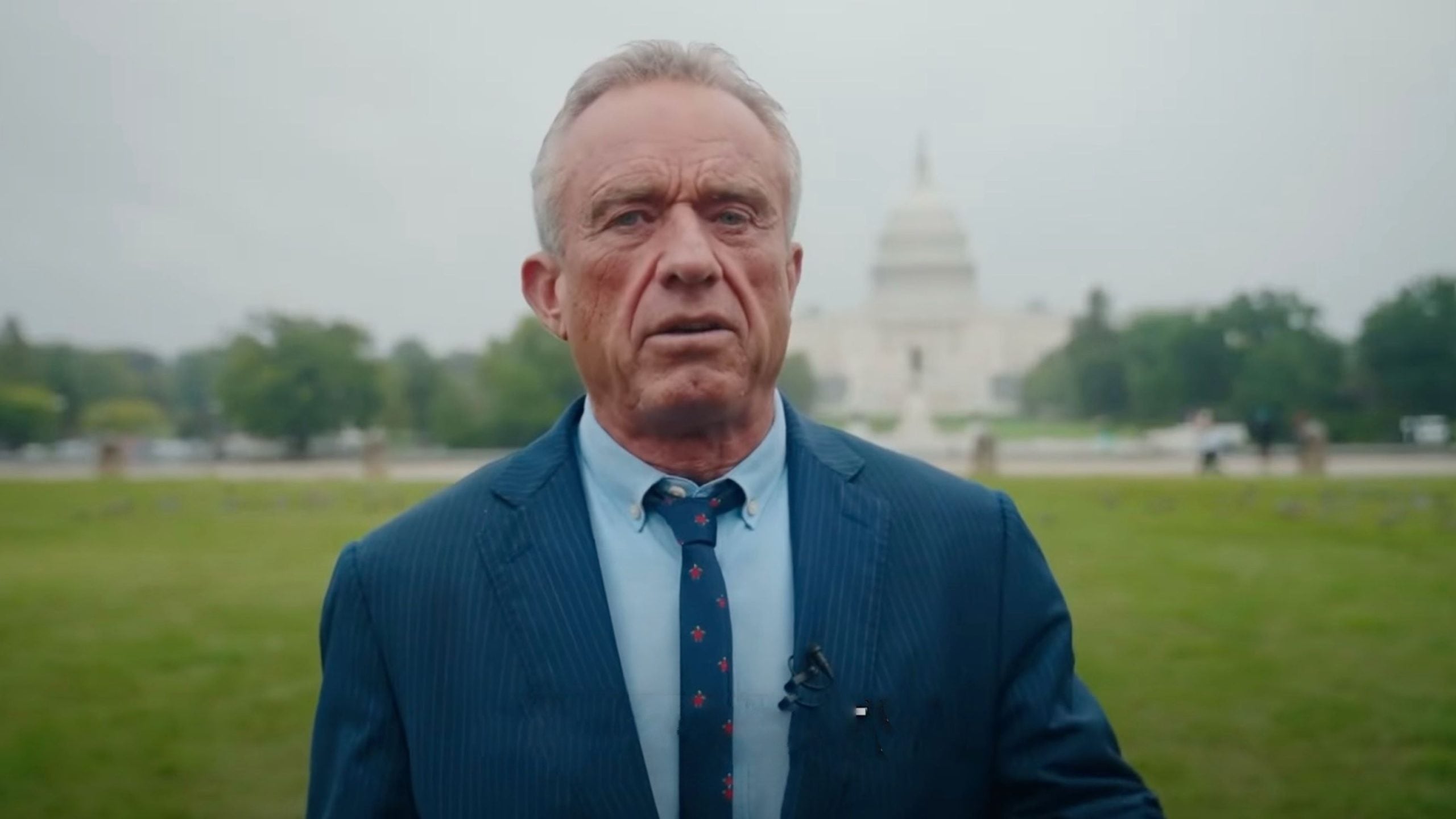 Robert F. Kennedy Jr. blue suit and tie standing outside with the U.S. Capitol building in the background.