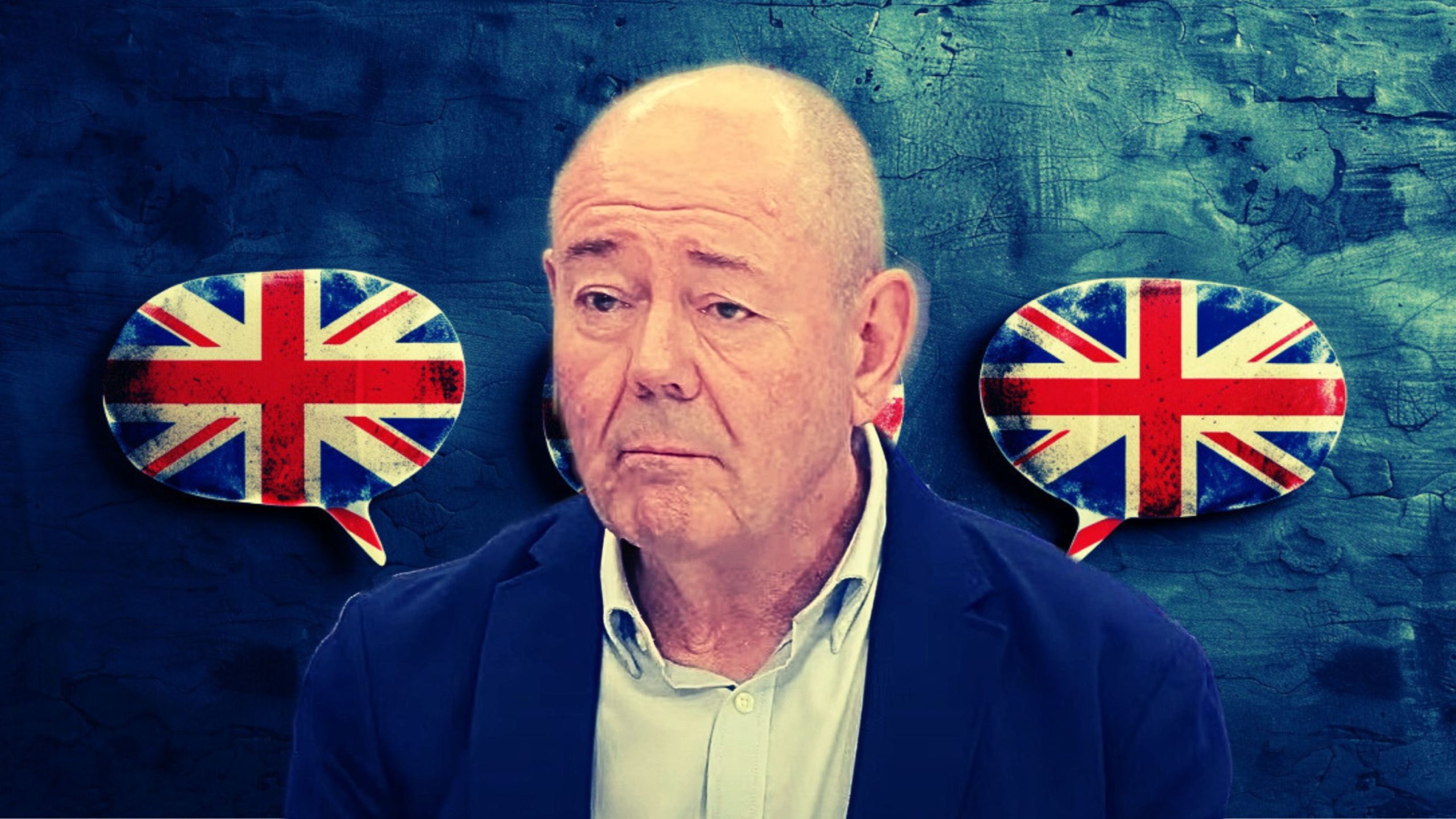 Portrait of Julian Foulkes in a blue jacket and light shirt against a textured blue background with two speech bubbles featuring the British flag on either side of his head.