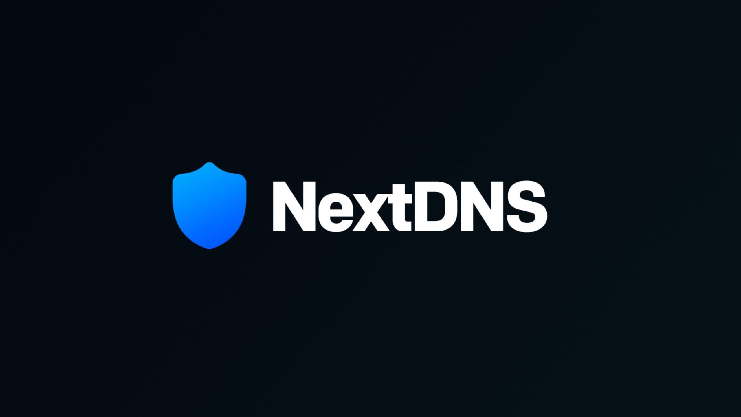 Blue gradient shield icon to the left of bold white text reading NextDNS on a dark background.