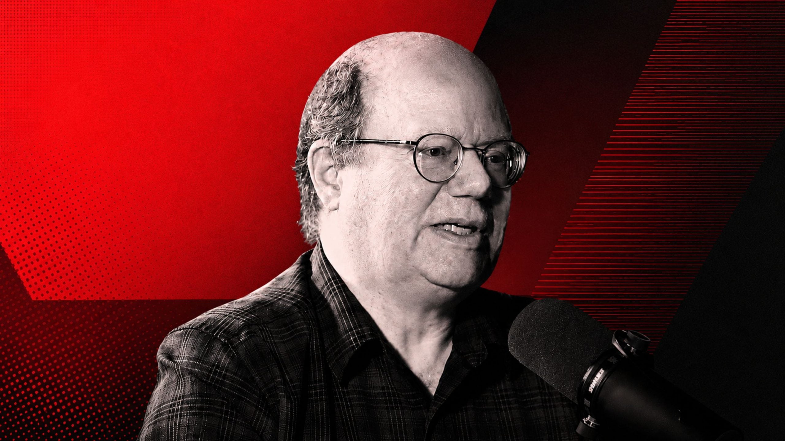 Larry Sanger with glasses speaking into a microphone against a stylized red and black background.