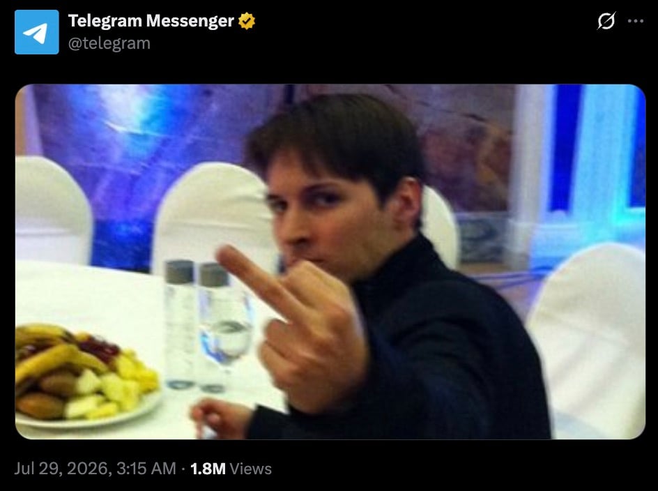 Durov sitting at a table with food, raising their middle finger towards the camera.