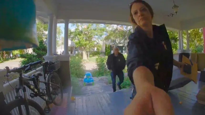 FBI reaching toward a doorbell camera on a porch while a man stands on the steps and bicycles lean nearby.