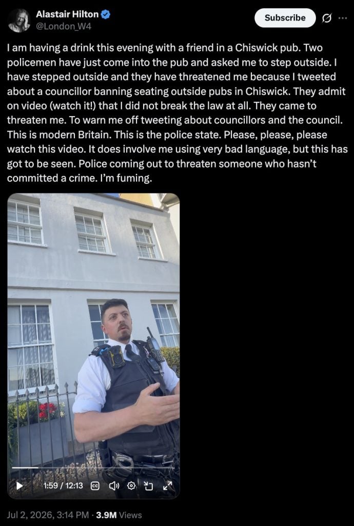 Screenshot of a tweet claiming police threatened the author outside a Chiswick pub, with a video still of a police officer outside a building