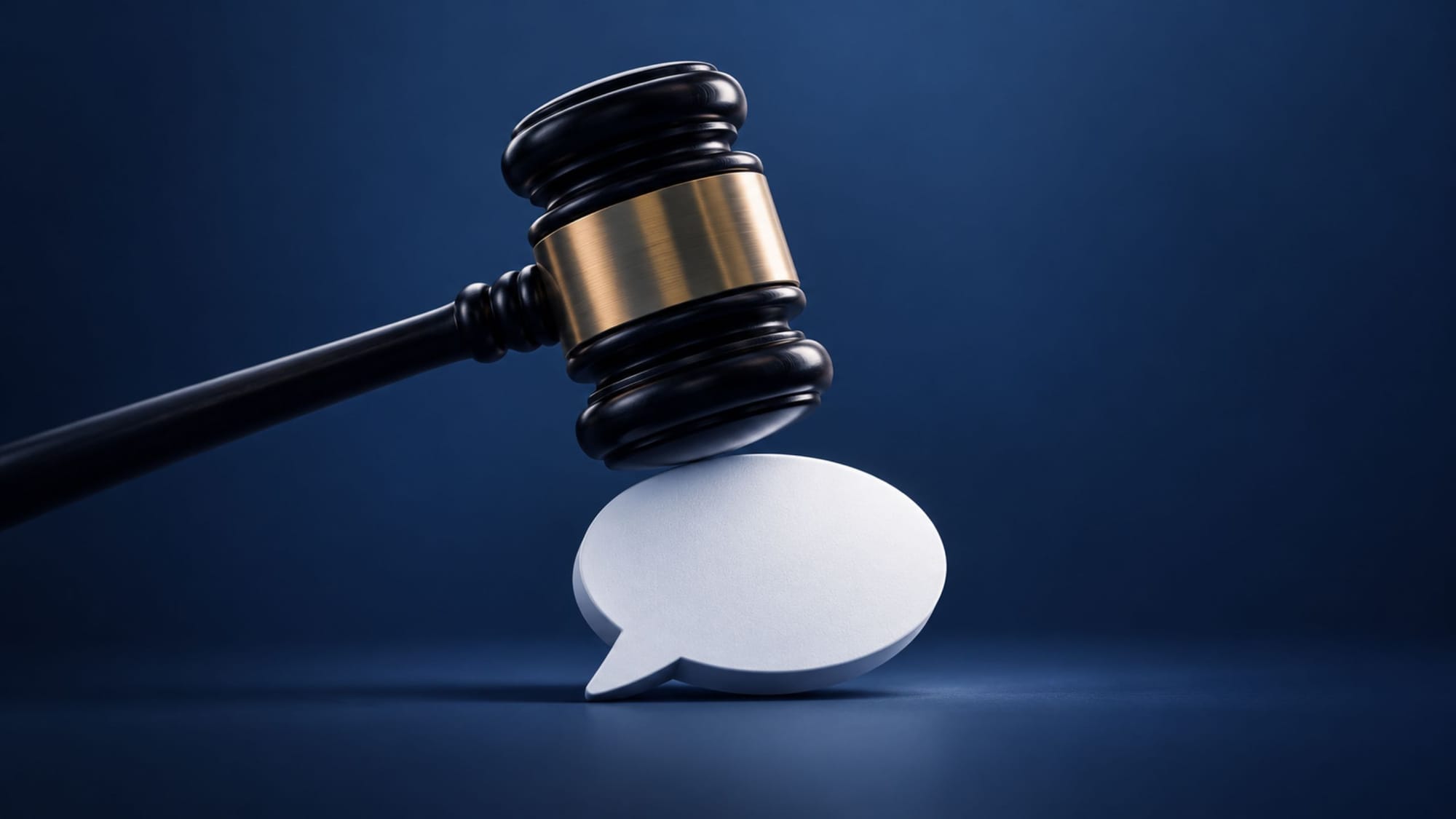 A judge's gavel striking down onto a white blank speech bubble against a blue background.